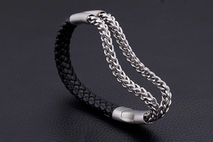 Macro shot of men's black braided leather and silver stainless steel chain bracelet