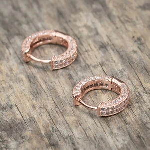 Detail of rose gold huggie earrings featuring double row pavé cubic zirconia inlay