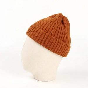 Detailed knit texture of ginger yellow winter beanie with classic cable pattern