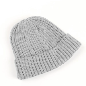 Detail of light gray cable knit beanie showing thick texture and folded cuff detail