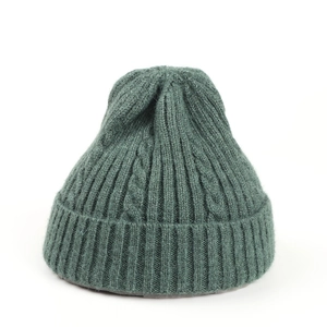Detail of dark green cable knit beanie showing thick texture and folded cuff edge