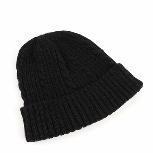 Detail of black cable knit beanie showing thick texture and soft ribbed cuff design