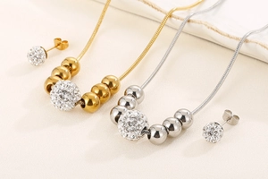 Vue détaillée des parures collier et boucles d'oreilles dorées et argentées en strass
