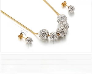 Détail d'un ensemble de bijoux boules en cristal pavé et chaîne serpent en acier doré