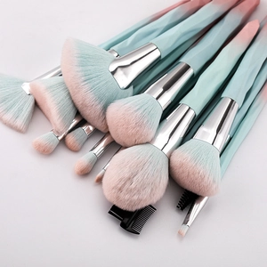 Detailed close-up of 15 makeup brushes with diamond handles and blue-pink gradient bristles