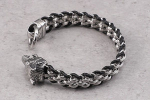 Detail of silver wolf head buckle on black braided leather punk bracelet for men