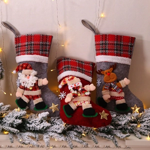 Three large plaid Christmas stockings with 3D dolls hanging by a festive fireplace