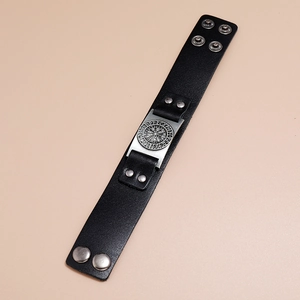 Detail of black leather Viking Vegvisir bracelet with adjustable metal snap buttons