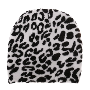 Close-up detail of knitted beanie featuring black and white leopard pattern and soft texture