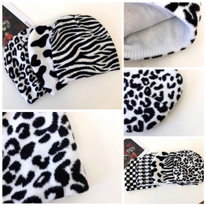 Detail showing various black and white knitted beanies with animal and plaid patterns