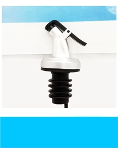 Close-up of a silver oil bottle pourer with black lever and rubber sealing ring detail