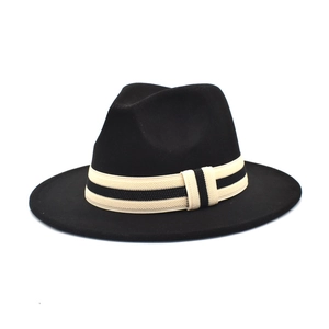 Detailed close-up of a black wool fedora hat featuring a beige and black striped ribbon band