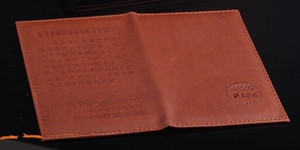 Detailed close-up of brown PU leather passport cover with custom engraved business logo