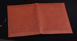 Detail of brown PU leather passport holder featuring fine stitching and custom gold lettering