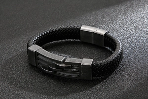 Macro detail of men's braided leather bracelet with vintage magnetic steel clasp