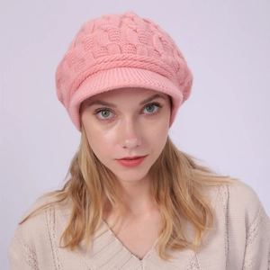 Detalle de boina de punto trenzado rosa con forro polar y visera de punto para mujer