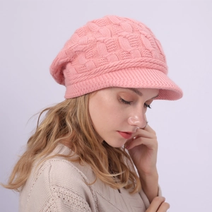 Primer plano de gorro de punto rosa con visera mostrando textura de lana suave de invierno