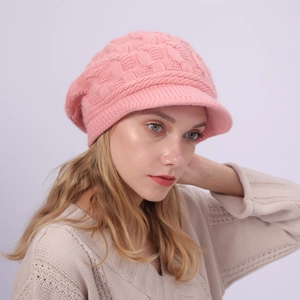 Detalle de la textura de punto rosa grueso y el patrón trenzado en el gorro de invierno