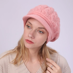 Detalle de textura de punto grueso y visera en gorro de invierno rosa para mujer