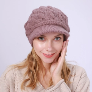 Detalle de punto trenzado y visera en gorro de invierno cálido rosa empolvado mujer