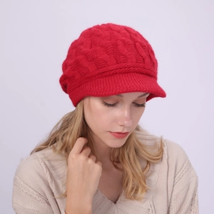 Detalle del tejido de trenzas en esta gorra roja de punto para mujer de invierno