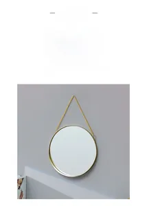 Detail view of round gold wall mirror with slim iron frame and sleek hanging chain