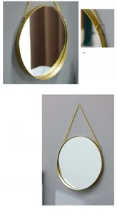Detail view of round gold metal frame mirror with sleek hanging chain design