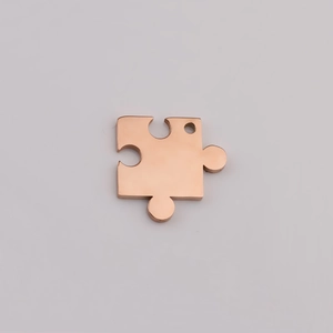 Detailed close-up of rose gold puzzle piece pendant with polished mirror finish surface