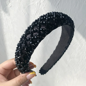 Close-up of black beaded headband featuring a detailed grid pattern and woven base