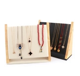 Detail of wooden jewelry necklace stands with beige and black velvet display panels