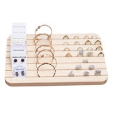 Detailed view of a multi-slot wooden jewelry display tray for rings and earrings