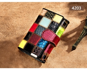 Détail du portefeuille en cuir multicolore avec textures animales sur fond en daim
