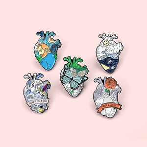 Artistic anatomical heart enamel pins with Van Gogh, waves, and butterflies designs