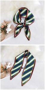 Detailed view of striped skinny scarf with burgundy edges on a white fur background