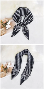 Close-up of black and white striped twilly scarf with geometric EM letter logo on faux silk