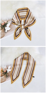 Detail of striped silk skinny scarf in earth tones tied and laid on white fur background