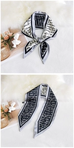 Detailed view of elegant black and white silk scarf with cursive script pattern
