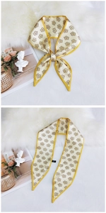 Detail of floral pattern silk twilly with yellow satin borders on plush background