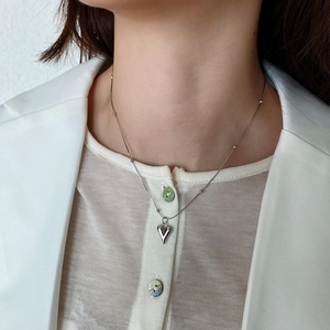 Close-up of 925 silver heart necklace on neck, featuring small beads on a fine chain