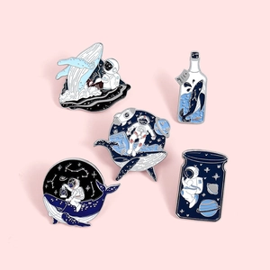 5-piece astronaut and whale enamel pins set with space ocean theme on pink backdrop