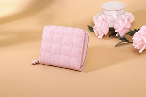 Close-up of pink faux leather mini wallet with quilted stitching and zipper closure