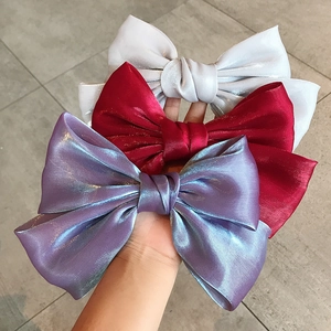 Three elegant satin bow hair clips in white, burgundy, and iridescent purple colors