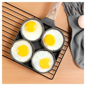 Top view of a grey stone non-stick frying pan with four eggs and a wooden handle