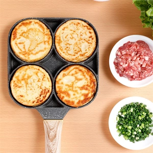 Macro view of non-stick four-hole maifan stone pan with cooked burgers and wood-style handle