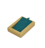Detail view of champagne gold jewelry box with dark green velvet insert and pull tab