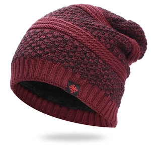 Detailed view of burgundy knit hat featuring thick fleece lining and snowflake patch detail