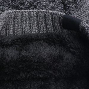 Detail of warm grey knit texture and thick black fleece lining on a winter beanie hat