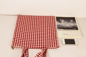 Detailed top view of red gingham fabric tote bag with zipper closure and dual handles