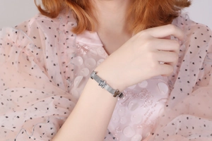 Bracciale a maglia argento con ciondoli a stella al polso, design stile cinturino d'orologio