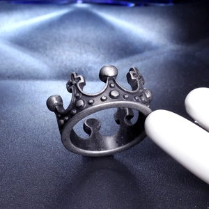 Detail view of a vintage silver crown ring made of stainless steel on a display finger
